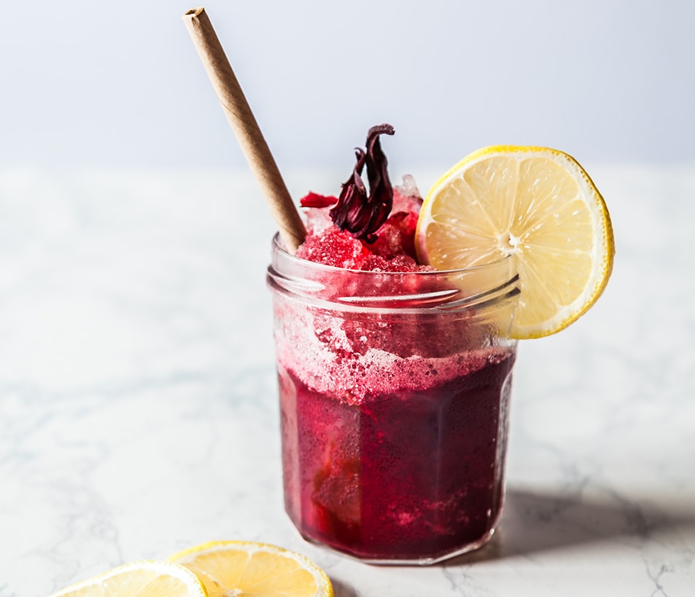 Hibiskus-Limonade mit Zitrone auf Marmortisch