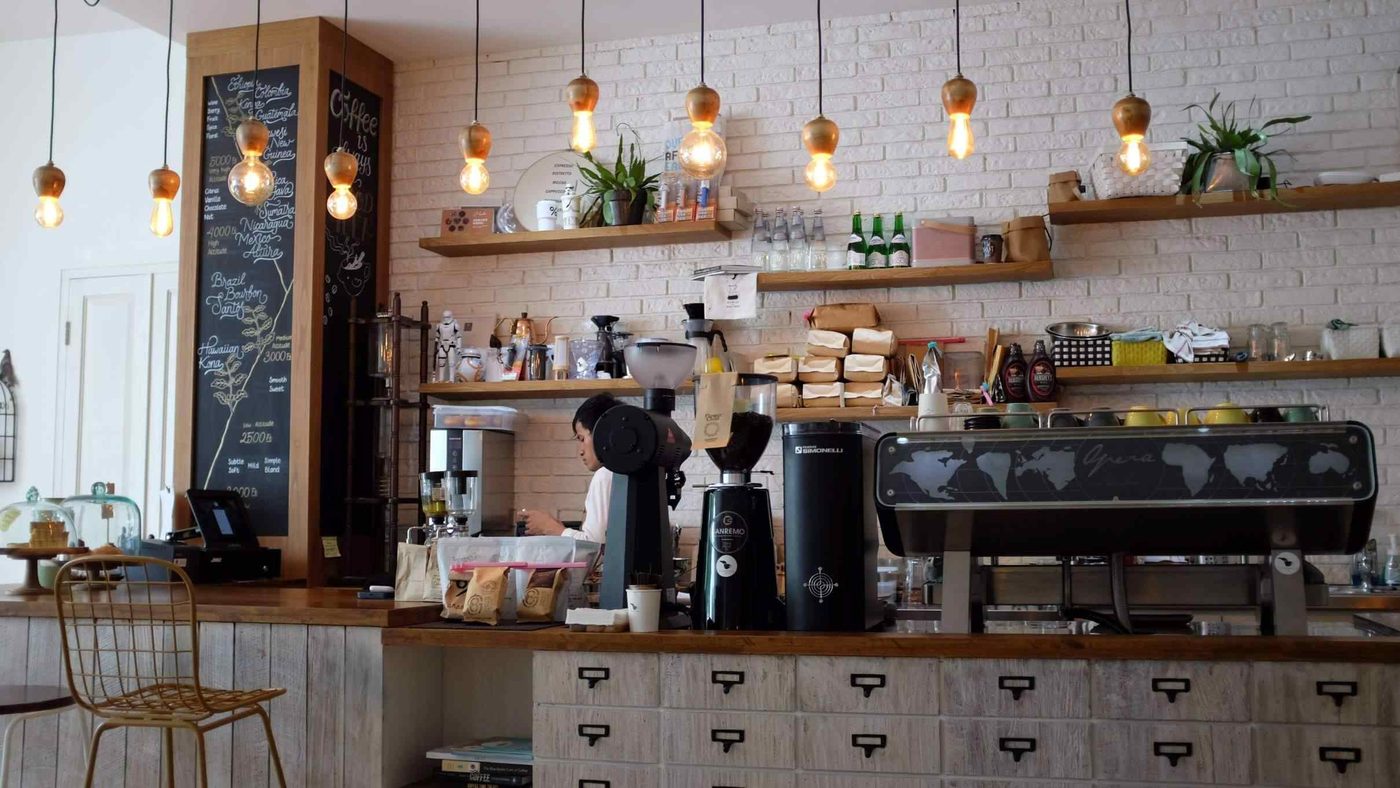 Espressomaschine an der hellen Café-Theke aus Holz und Weiß